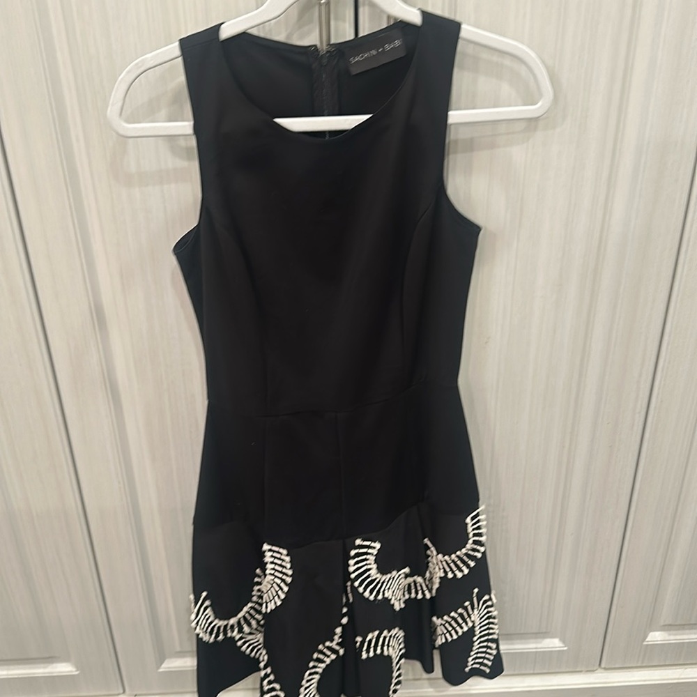 Black sleeveless Sachin + Babi dress. White pretty design on bottom.